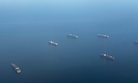 Five cargo ships sailing across the Panama Canal.