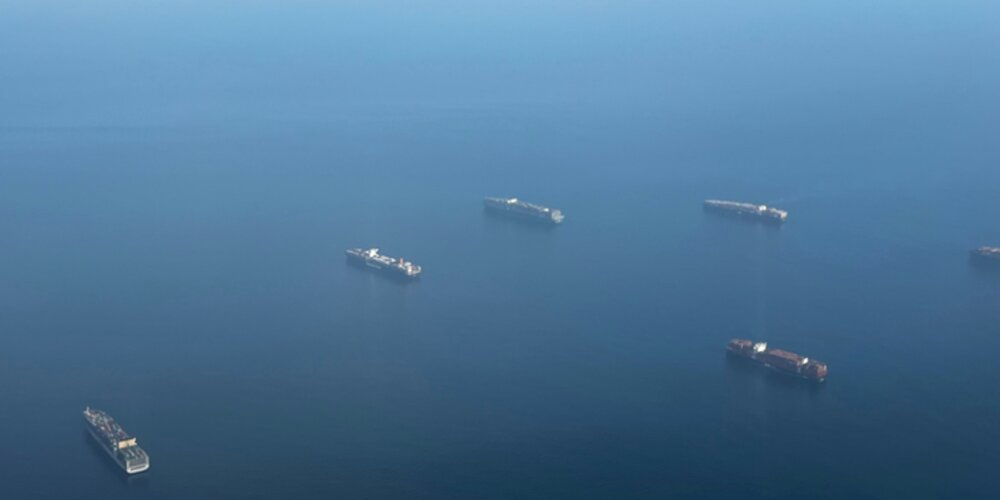 Five cargo ships sailing across the Panama Canal.